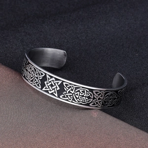Macro shot of vintage Viking patterns engraved on a polished steel open cuff bracelet