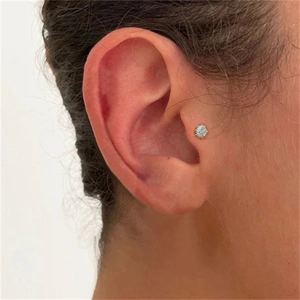 Macro view of solar flare style s925 silver ear stud with white opal on a real ear tragus