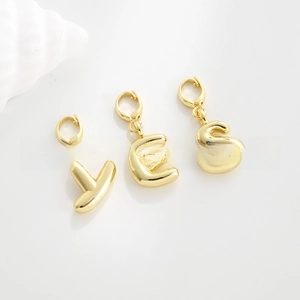 Macro shot of 18k gold plated letter pendants Y E S with lobster clasp connectors