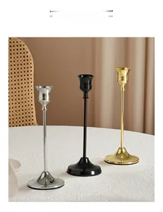 Close-up of modern tulip-shaped metal candle holders in gold, black and silver finishes