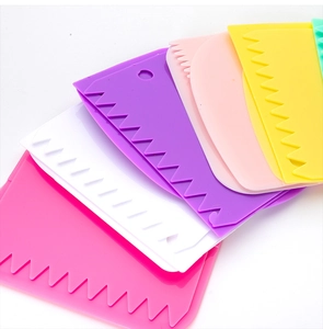 Detailed view of 5 colorful plastic dough scrapers with smooth and jagged edges on white background
