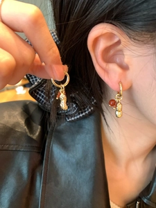 Gros plan sur les boucles d'oreilles cacahuète avec perles rouges en cristal