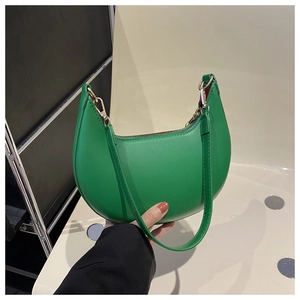 Detail of green crescent hobo bag featuring smooth faux leather and gold metal hardware