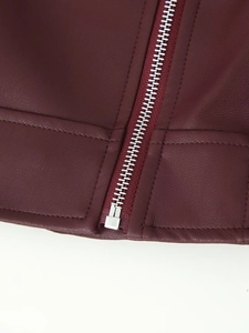 Makroaufnahme von Silber-Reißverschluss und hochwertiger Naht an weinroter Lederjacke