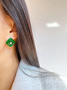 Detail of vintage square emerald stud earring with clear center stone on model