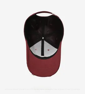Detail of burgundy baseball cap interior with six-panel stitching and distressed brim
