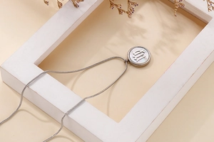 Macro detail of silver stainless steel Virgo zodiac pendant with a delicate snake chain