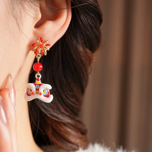 Macro shot of festive Chinese lion dance earrings with red beads and plush velvet texture