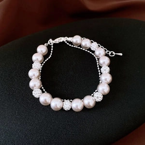 Macro détaillée d'un bracelet de perles avec sphères de zircon sur fond de soie élégant
