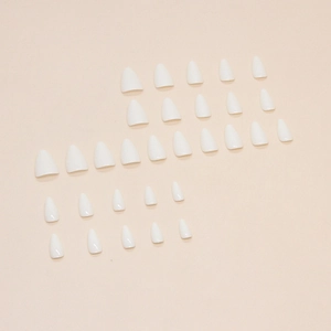 Glossy white almond shaped press-on nails set of 24 pieces on a warm beige background