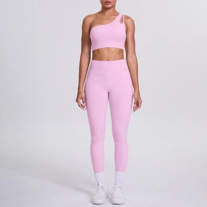 Pink one-shoulder sports bra and high-waist yoga pants fitness set close-up