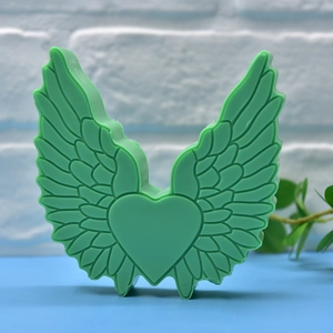 Silicone wing-shaped heart mold in soft green for DIY soaps, candles, and resin crafts