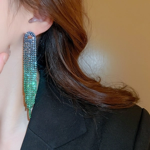 Close-up of tassel earrings with blue to green gradient rhinestones on model