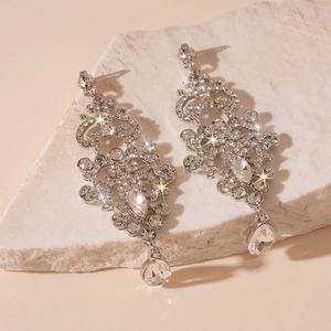 Close-up of luxury silver drop tassel earrings with sparkling rhinestones on stone base