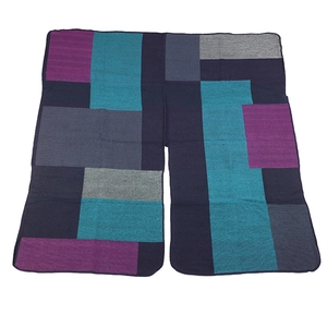 Detail shot of multi-color geometric block knit shawl in navy blue and purple tones