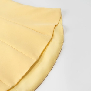 Détail de l'ourlet plissé jaune et des coutures fines sur cette robe longue élégante