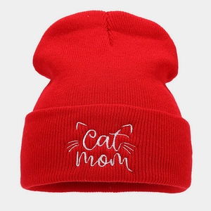 Close-up of Cat Mom embroidery and cat whiskers on a red ribbed knit beanie hat
