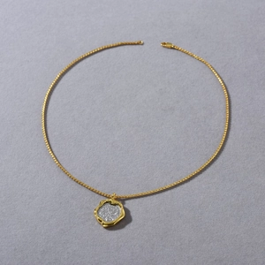 Detailed macro view of 18k gold-plated brass necklace with vintage coin style pendant