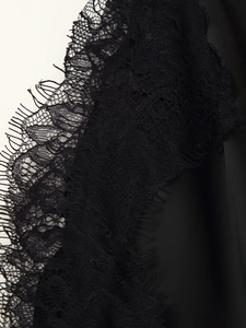 Nahaufnahme von schwarzem Spitzenbesatz und Seidentextur an einem Slip-Kleid