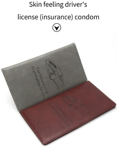 Detail view of grey and red leather car document holders with embossed car patterns