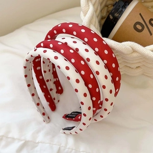 Three vintage red and white polka dot sponge headbands in a soft lifestyle setting
