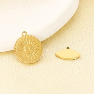 Detail view of 18K gold-plated stainless steel sun and evil eye pendants for jewelry making