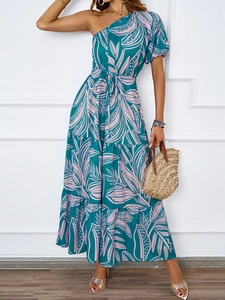 Détail de robe longue bohème à une épaule avec imprimé tropical et jupe à plusieurs niveaux
