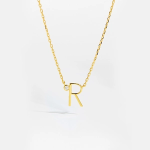 Detail of gold S925 sterling silver necklace with letter R pendant and small diamond