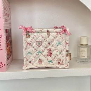 Close-up of quilted fabric storage basket with cartoon bear prints and pink bows