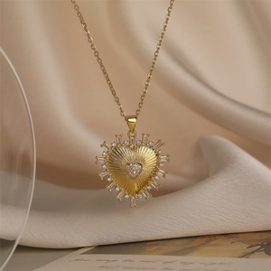 Détail macro d'un collier cœur plaqué or avec zircons baguette sur soie beige