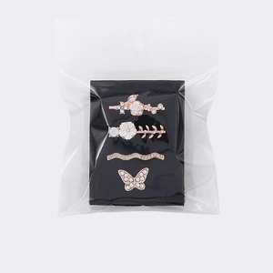 Close-up of four rose gold charms for silicone watch bands with crystals and floral motifs