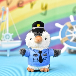 Nahaufnahme eines süßen Pinguin-Plüschanhängers in blauer Polizeiuniform und Hut