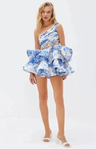 Detail of floral mini dress showing one-shoulder cut and layered ruffle skirt with floral print