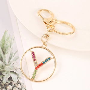 Detail of golden metal keychain featuring letter Y pendant with colorful rhinestones