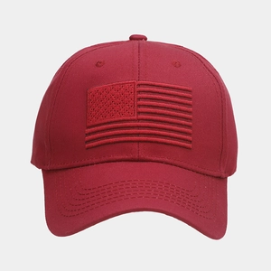 Close-up of deep red baseball cap featuring detailed American flag embroidery on cotton twill