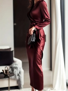 Close-up of wine red satin wrap dress showing fabric texture and waist tie detail
