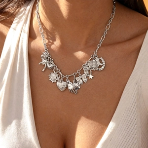 Close-up of silver multi-pendant necklace with heart, star, and bow charms on model