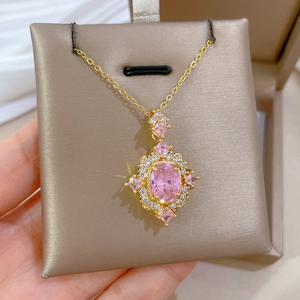 Close-up of golden vintage necklace with pink oval stone and sparkling crystals