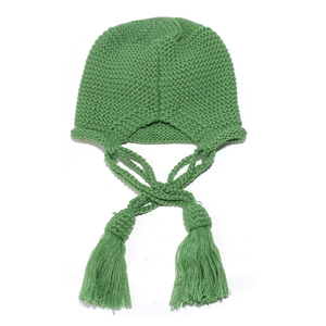 Detail of green knitted beanie with long braided straps and large decorative tassels