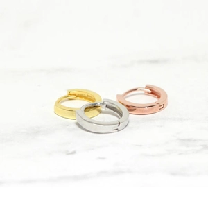 Detailed view of minimalist S925 silver huggie earrings in gold, silver, and rose gold