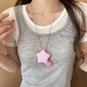 Primo piano della collana con ciondolo a stella viola e fiori indossata da modella