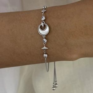Detail of adjustable silver sun and moon bracelet with mother of pearl and zircon stones
