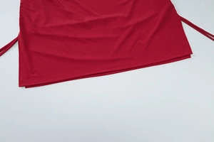 Detail of red drawstring hem on a ruched mini dress showing soft fabric texture