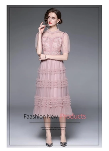 Détail de la robe en maille rose à volants avec broderie florale et manches bouffantes