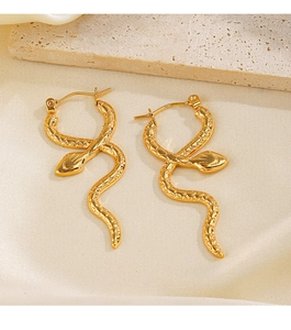 Detailed view of golden snake hoop earrings on beige silk and stone texture background