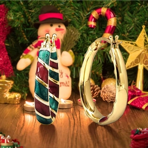Detail of festive Christmas hoop earrings with red green enamel and gold plating