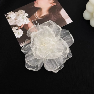 Vue détaillée d'une pince à cheveux fleur en organza blanc avec perles centrales