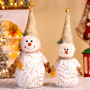 Close-up of white and gold plush snowmen pair in a warm indoor Christmas holiday setting