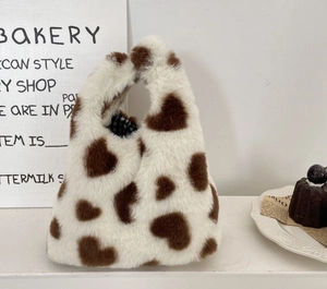 Détail du sac à main en peluche à motif cœur montrant la texture et la doublure