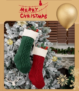 Detail of red and green cable knit Christmas stockings hanging on a festive tree